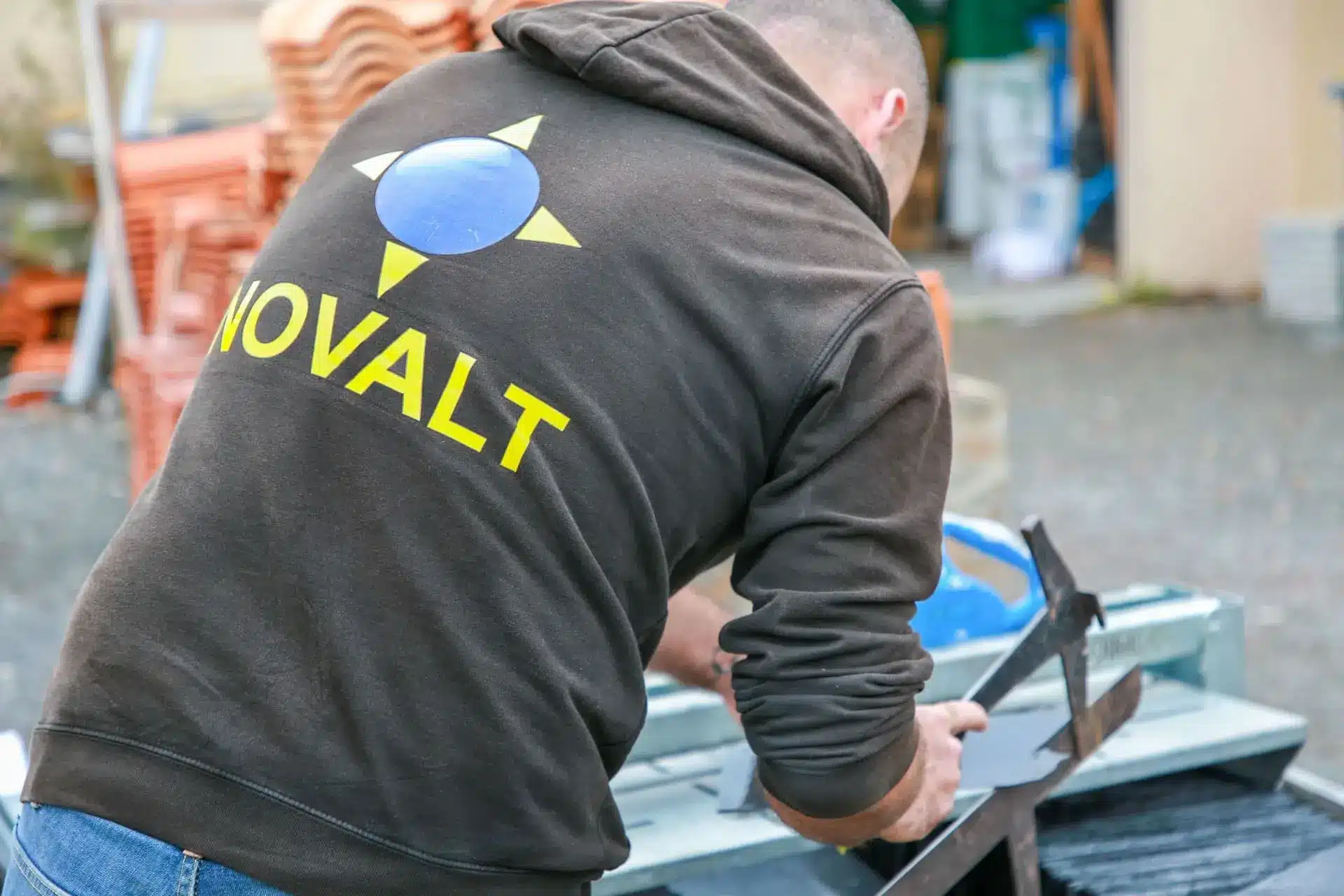 Un employé de l'entreprise NOVALT coupant du zinc