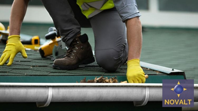 Un ouvrier de chez Novalt nettoie les gouttières après avoir fais un démoussage du toit